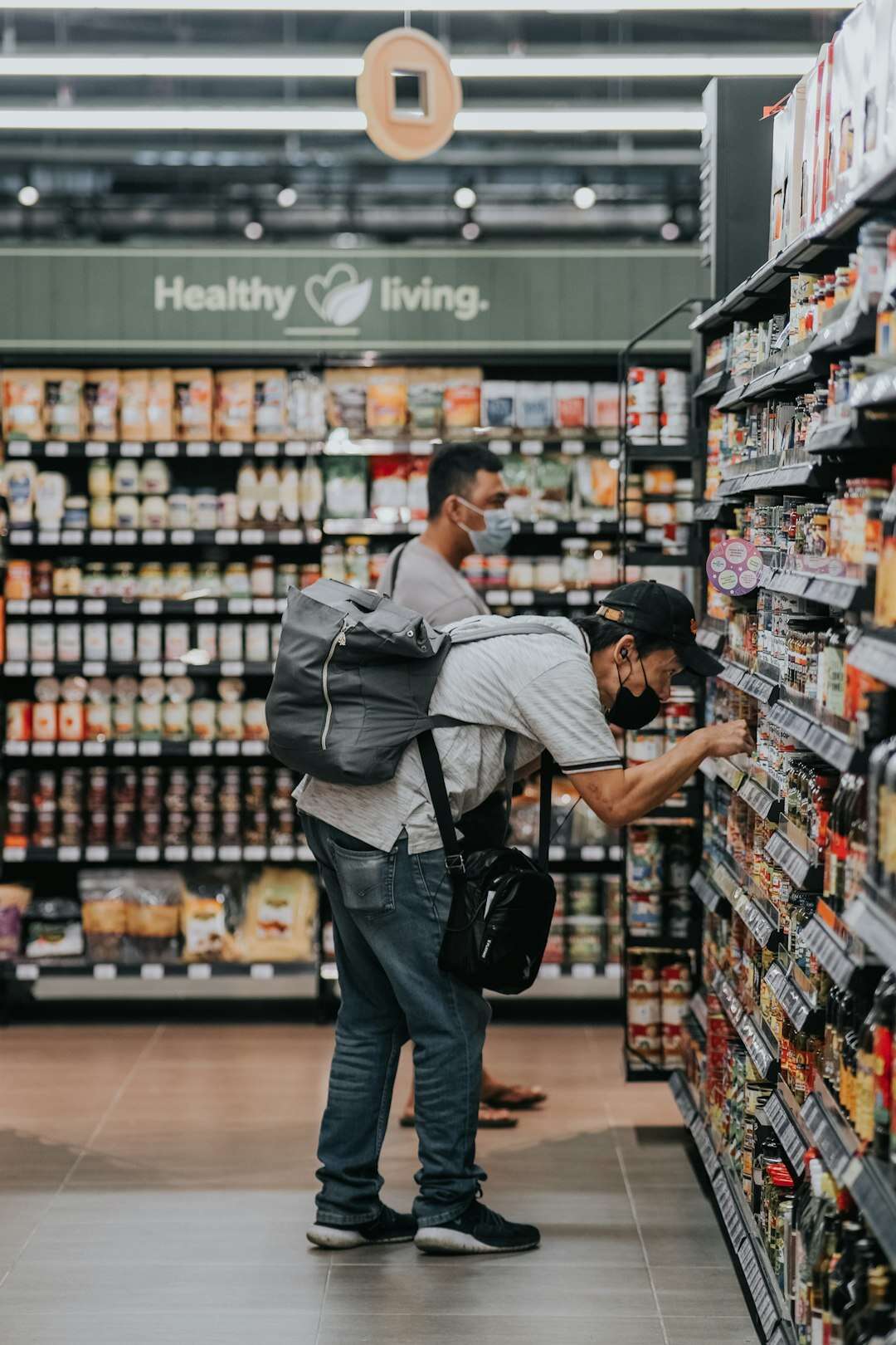 Uomo davanti allo scaffale del supermercato che legge l'etichetta di un prodotto