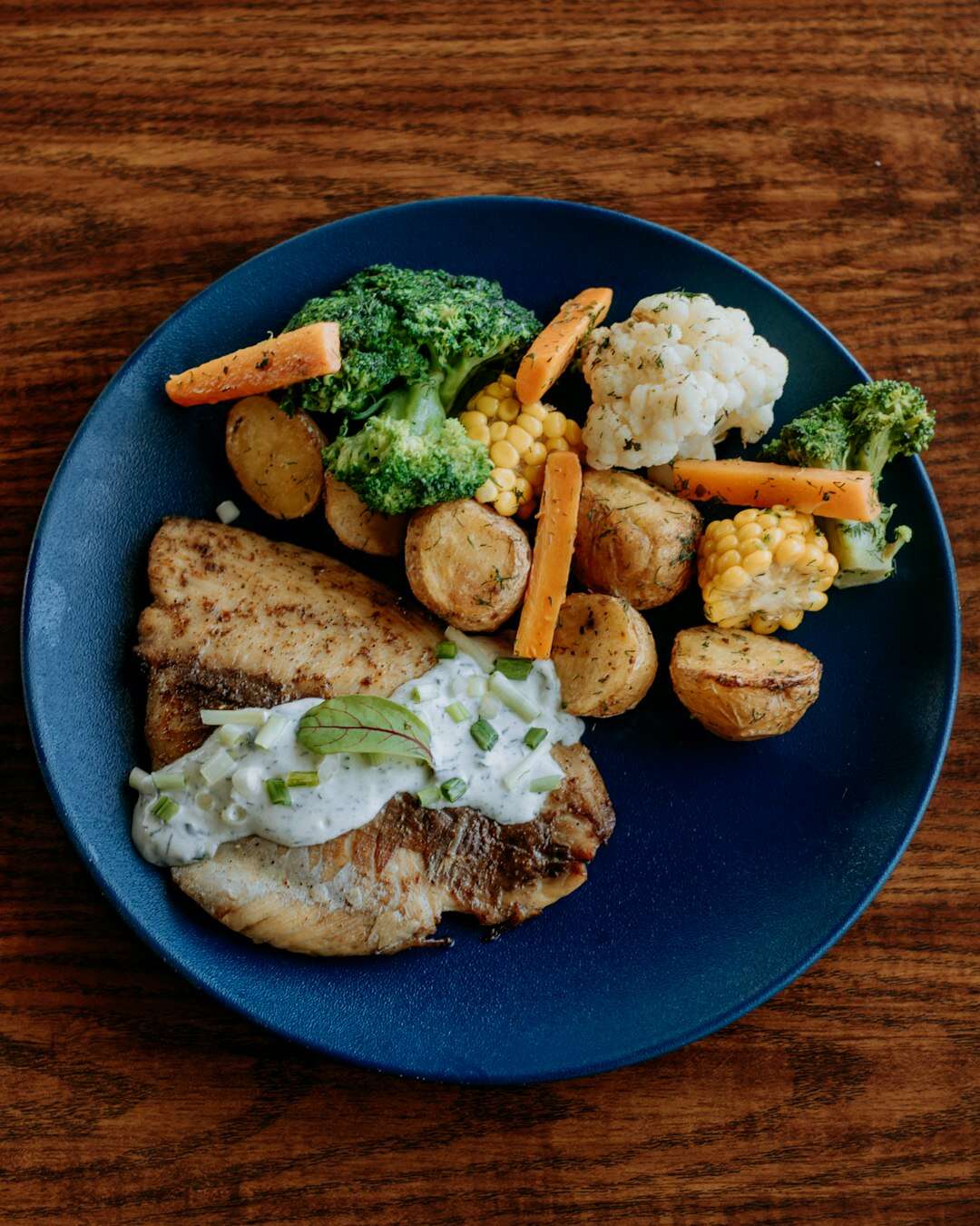 Piatto con pesce, verdure arrosto e patate: cibo vero per cambiare composizione corporea