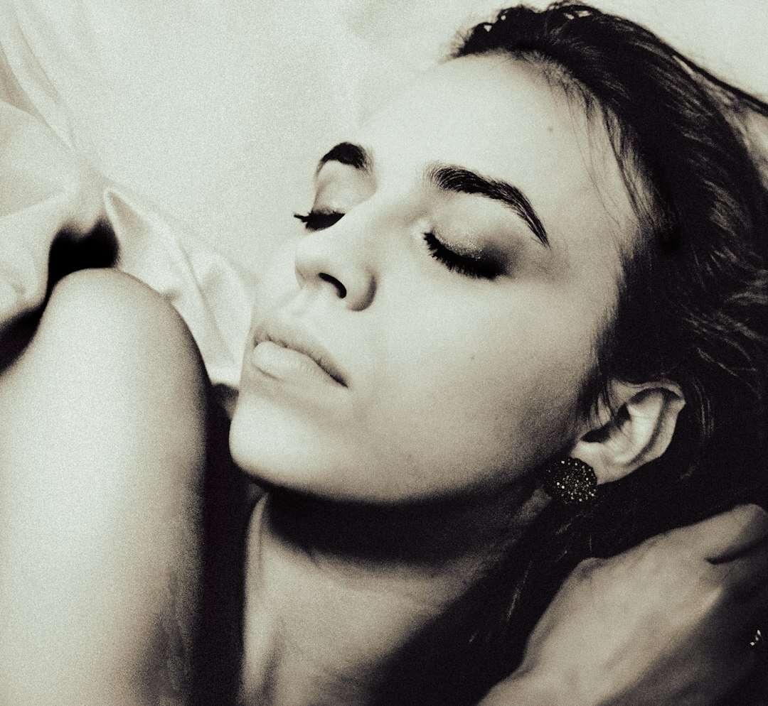 Donna che dorme serena nel suo letto: il sonno come nutrimento