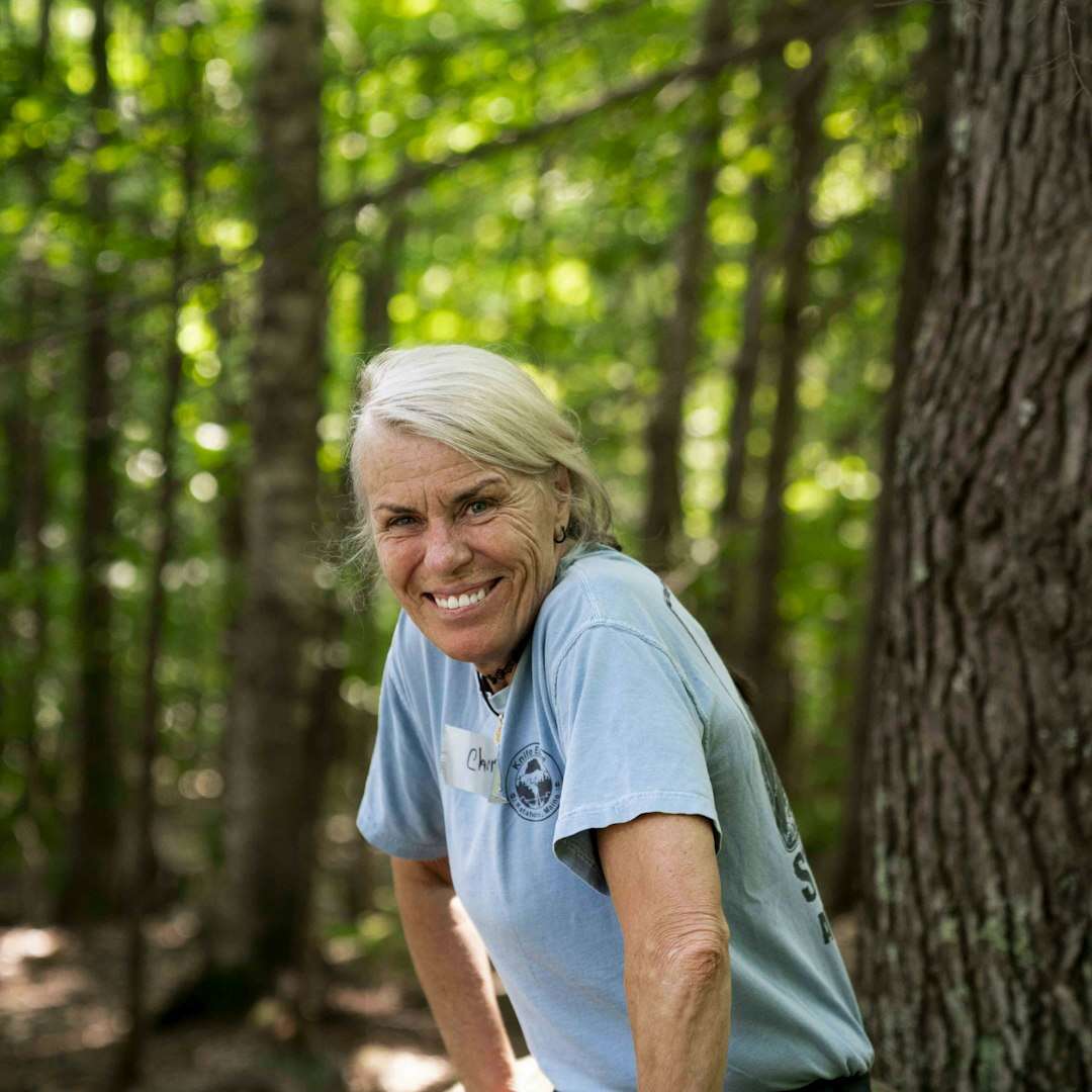 Donna sorridente e in forma durante un'escursione nel bosco